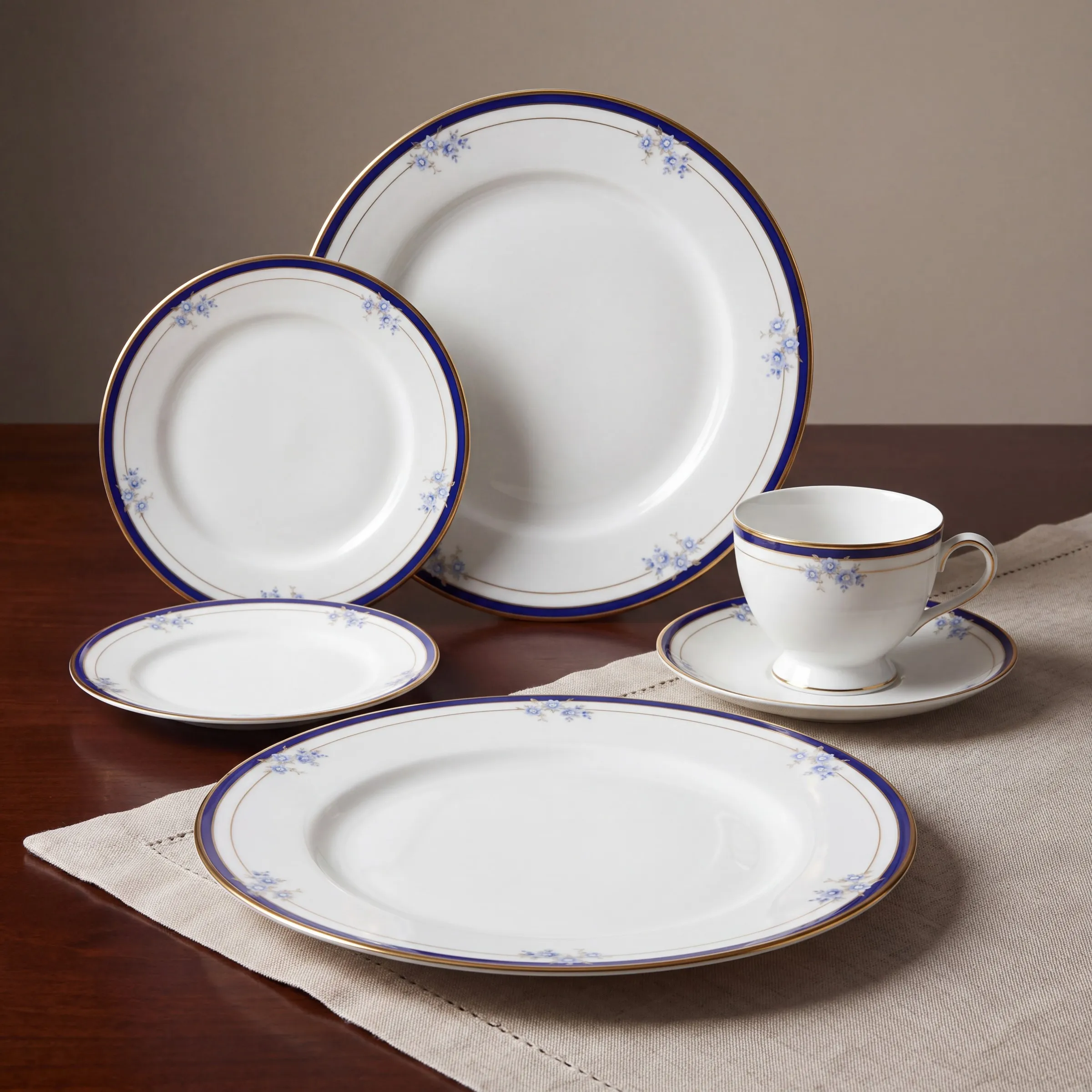The same setting arranged on linen, the cobalt band and gold rim catching the light